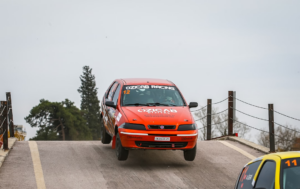 a red car driving down a road next to a yellow car — Foto por Ozicab Racing na Unsplash